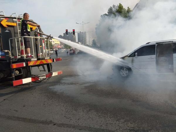 灑水車正在向燃燒的面包車高射噴水